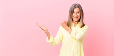 Güzel, orta yaşlı bir kadın kendini mutlu hissediyor ve zorluklarla yüzleşiyor veya kutlama yapıyor.