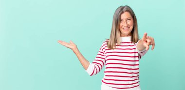 Güzel orta yaşlı bir kadın kamerayı işaret ederek seni seçiyor.