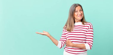 Orta yaşlı güzel bir kadın omuz silkiyor, kafası karışık ve kararsız.