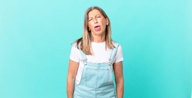 Güzel, orta yaşlı bir kadın. Tiksinmiş, rahatsız olmuş ve dili dışarı çıkmış.