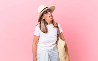 Oldukça orta yaşlı, neşeli ve asi tavırlı, şaka yapan ve dilini dışarı çıkaran bir kadın. yaz konsepti