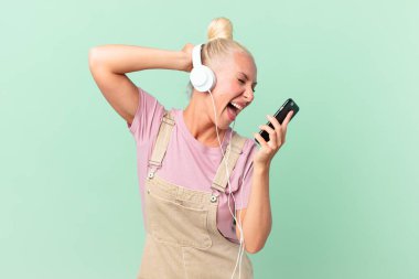 Güzel sarışın kadın kulaklıkla müzik dinliyor.