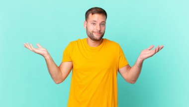 handsome blonde man feeling puzzled and confused and doubting