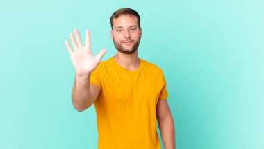 handsome blonde man smiling and looking friendly, showing number five