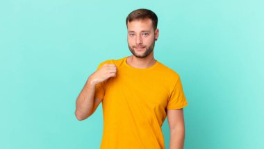 handsome blonde man looking arrogant, successful, positive and proud