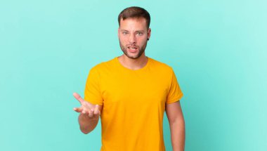 handsome blonde man looking angry, annoyed and frustrated