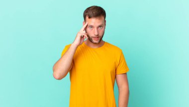 handsome blonde man looking surprised, realizing a new thought, idea or concept