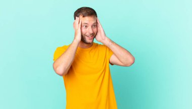 handsome blonde man feeling happy, excited and surprised