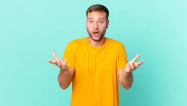 handsome blonde man feeling extremely shocked and surprised
