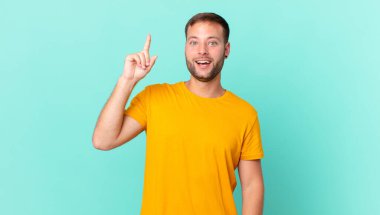 handsome blonde man feeling like a happy and excited genius after realizing an idea