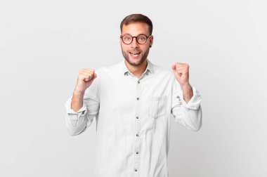 handsome blonde man feeling shocked,laughing and celebrating success