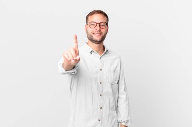 handsome blonde man smiling proudly and confidently making number one