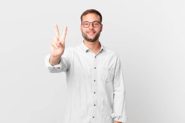handsome blonde man smiling and looking friendly, showing number two