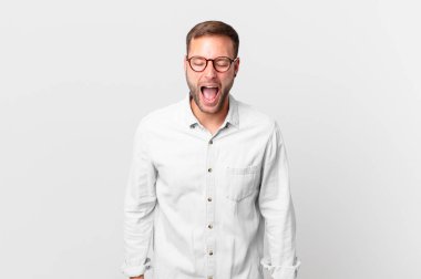 handsome blonde man shouting aggressively, looking very angry