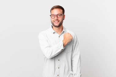 handsome blonde man feeling happy and facing a challenge or celebrating