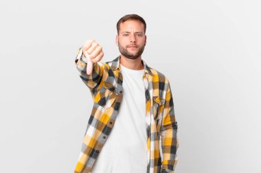 handsome blonde man feeling cross,showing thumbs down