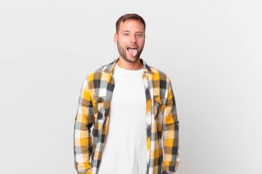 handsome blonde man with cheerful and rebellious attitude, joking and sticking tongue out