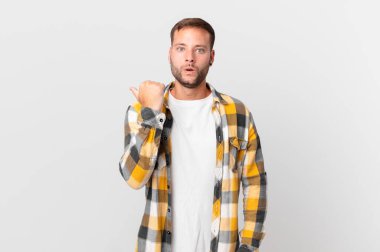 handsome blonde man looking astonished in disbelief