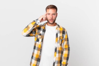 handsome blonde man looking surprised, realizing a new thought, idea or concept