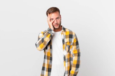 handsome blonde man feeling bored, frustrated and sleepy after a tiresome