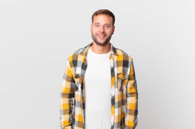 handsome blonde man looking happy and pleasantly surprised