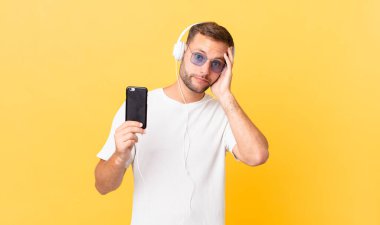 feeling bored, frustrated and sleepy after a tiresome, listening music with headphones and a smartphone