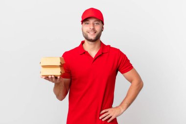 burger deliver man smiling happily with a hand on hip and confident