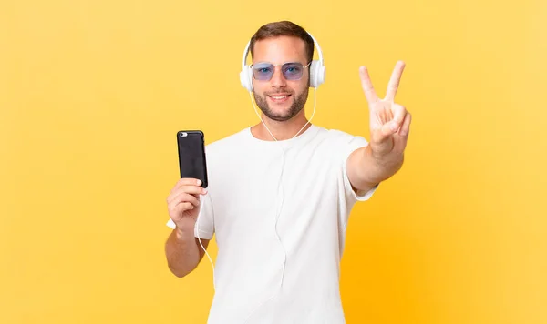 Smiling Looking Happy Gesturing Victory Peace Listening Music Headphones Smartphone — kuvapankkivalokuva