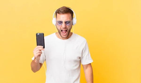 Shouting Aggressively Looking Very Angry Listening Music Headphones Smartphone — Stockfoto