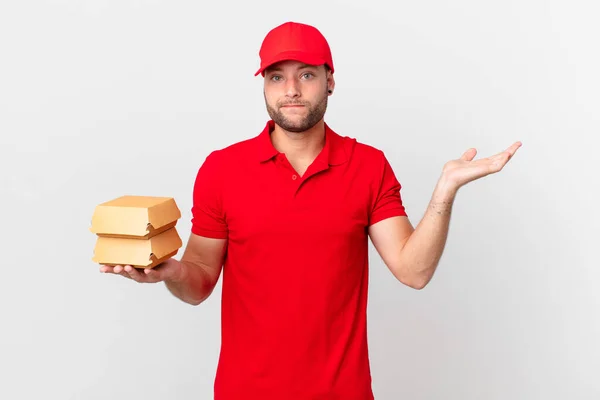 Burger Deliver Man Feeling Puzzled Confused Doubting — Stok fotoğraf