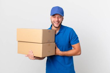 Paket teslimatı yapan adam komik bir şakaya yüksek sesle gülüyor.