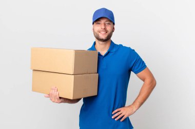 Paket teslim adam mutlu bir şekilde gülümseyerek kalça ve kendinden emin bir elle