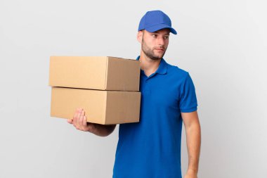 Paket teslim adam üzgün, üzgün ya da kızgın hissediyor ve yana bakıyor