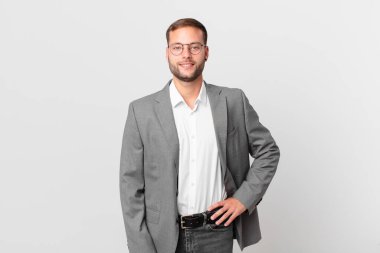 handsome businessman smiling happily with a hand on hip and confident