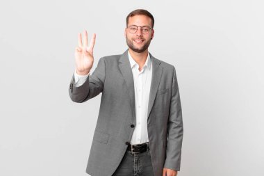 handsome businessman smiling and looking friendly, showing number three