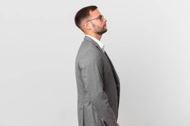 handsome businessman on profile view thinking, imagining or daydreaming