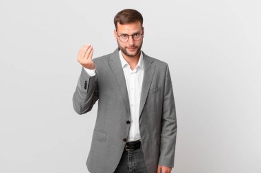 handsome businessman making capice or money gesture, telling you to pay