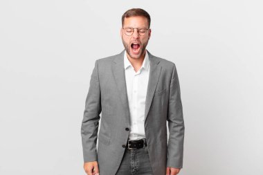 handsome businessman shouting aggressively, looking very angry