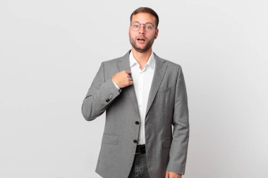 Yakışıklı işadamı ağzı açık, şaşkın ve şaşkın bir şekilde kendini işaret ediyor.