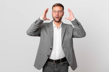 handsome businessman screaming with hands up in the air