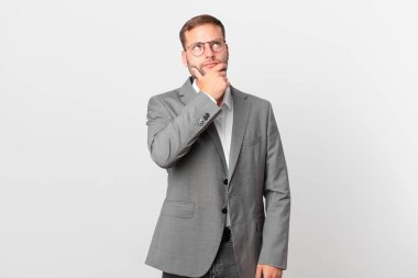 handsome businessman thinking, feeling doubtful and confused