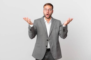handsome businessman feeling extremely shocked and surprised