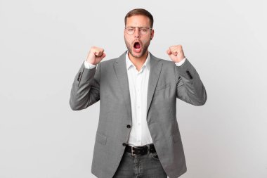 handsome businessman shouting aggressively with an angry expression