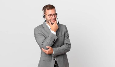 telemarketer businessman smiling with a happy, confident expression with hand on chin