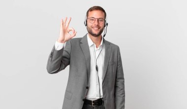 telemarketer businessman feeling happy, showing approval with okay gesture