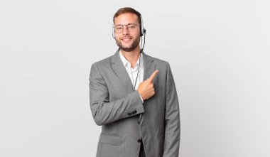 telemarketer businessman smiling cheerfully, feeling happy and pointing to the side