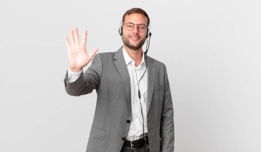 telemarketer businessman smiling and looking friendly, showing number five