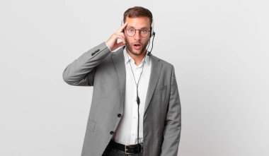telemarketer businessman looking surprised, realizing a new thought, idea or concept