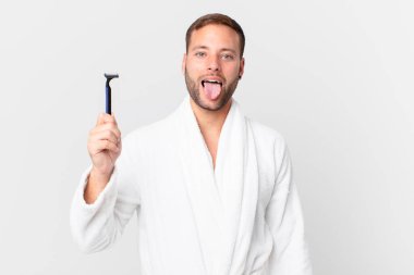 Yakışıklı, sarışın, neşeli ve asi tavırlı, şaka yapan ve dilini dışarı çıkaran bir adam. traş konsepti