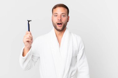 Yakışıklı sarışın adam çok şaşırmış ya da şaşkın görünüyor. traş konsepti